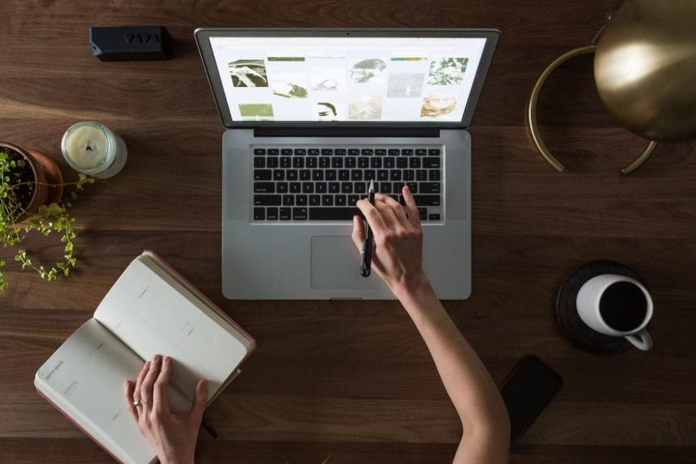 A laptop on a wooden desk with a website open on the screen